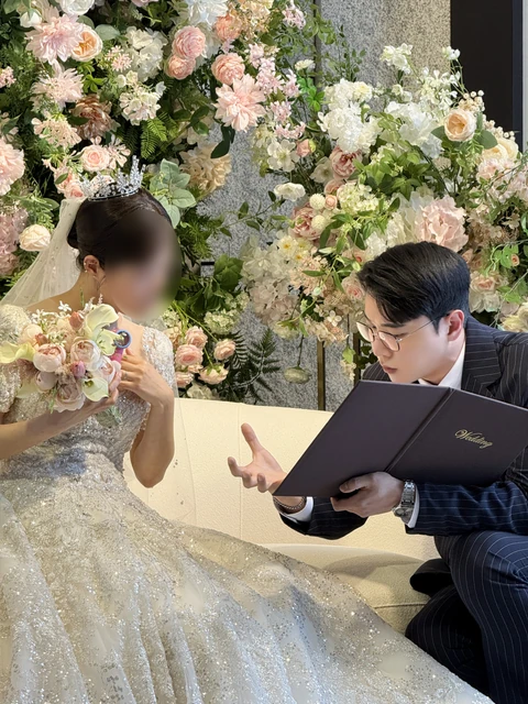 신부님과 예식 자료를 보며 대화하는 김민울 사회자